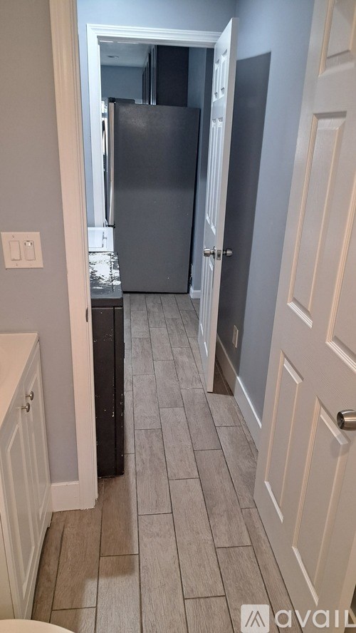 A kitchen with a black fridge and white cabinets.