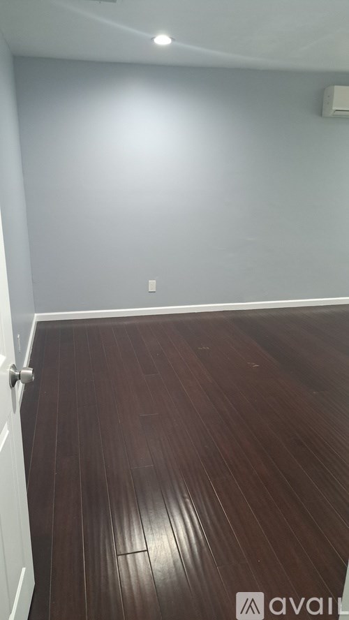 A room with wooden flooring and a white door.