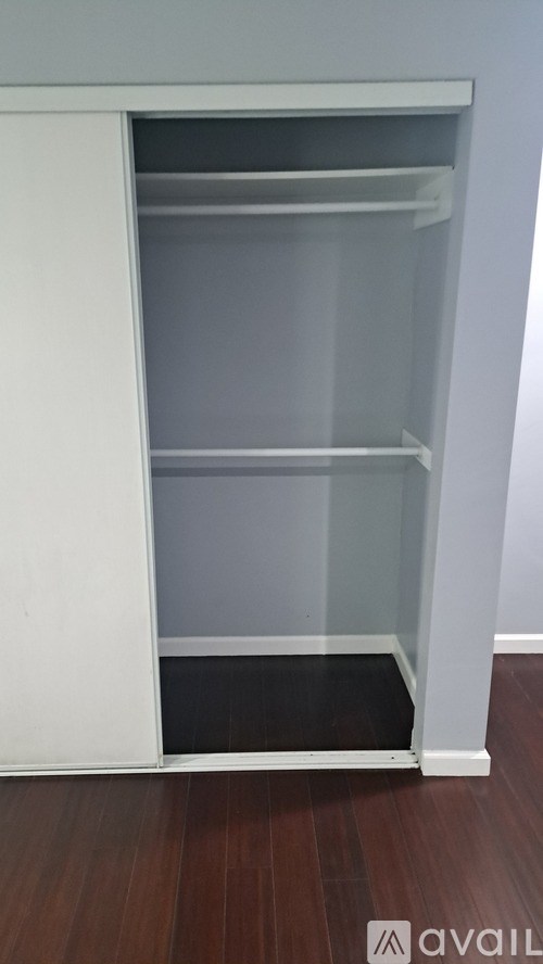 A white open pantry with a door and a shelf.