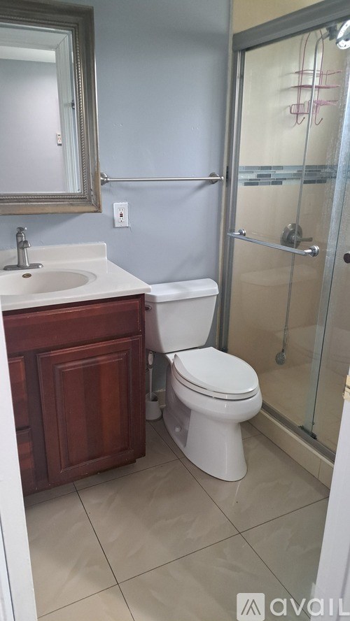 A bathroom with a toilet, sink, and shower.