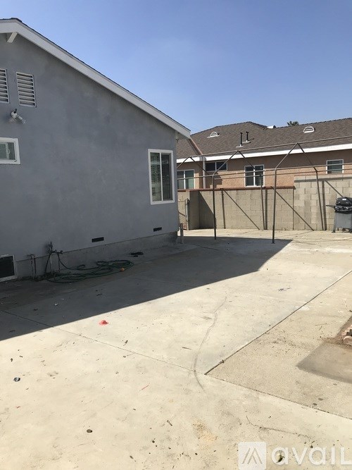 A grey house with a white door and a brown roof.