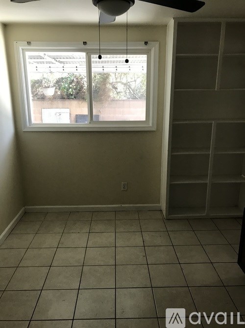 A room with a window and a fan.