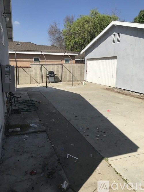 A backyard with a black tarp on the ground.