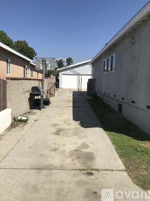 A concrete driveway leads to a garage in a residential area.