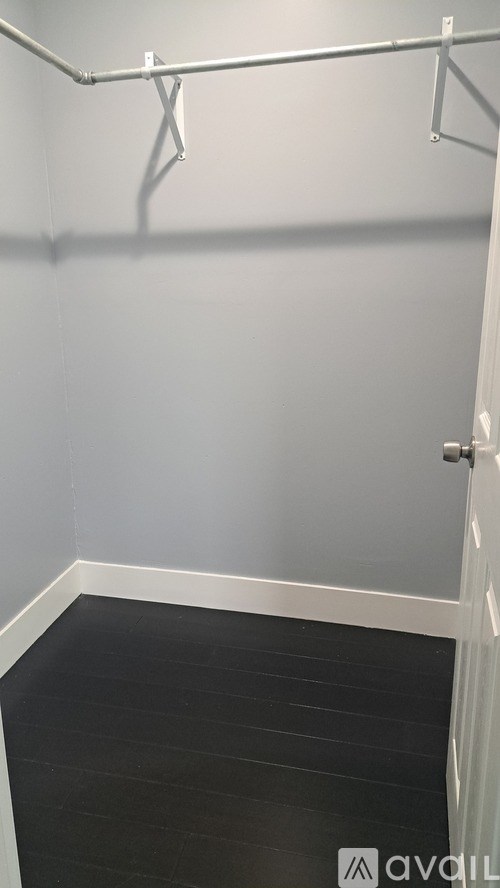 A room with a white door and a grey wall.