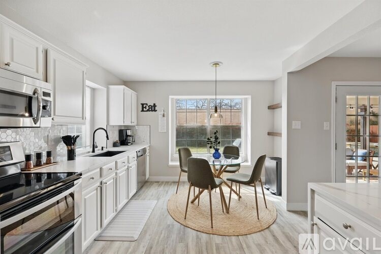 A modern kitchen with a dining table and chairs.