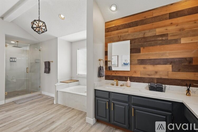 A bathroom with a wooden wall panel and a glass shower area.