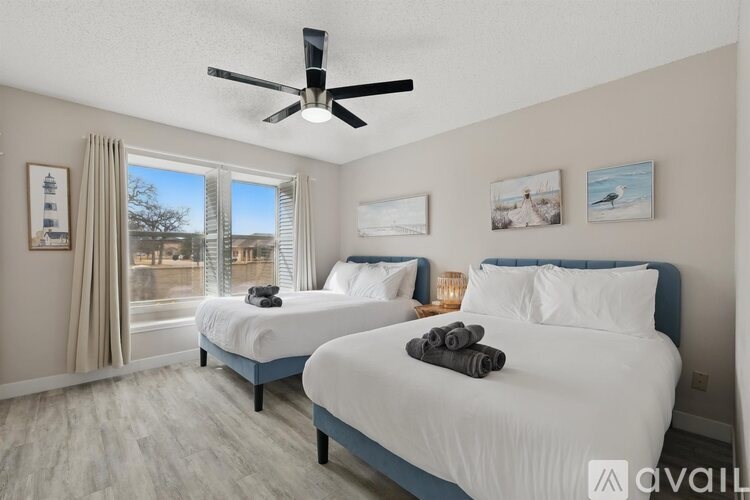 A bedroom with two beds and a ceiling fan.