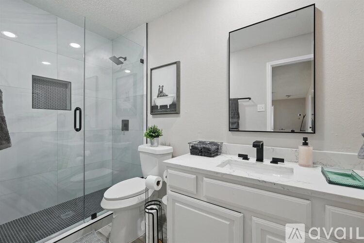 A bathroom with a toilet, sink, and mirror.