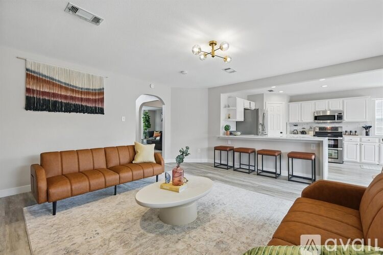 A living room with a brown leather sofa and a white coffee table.
