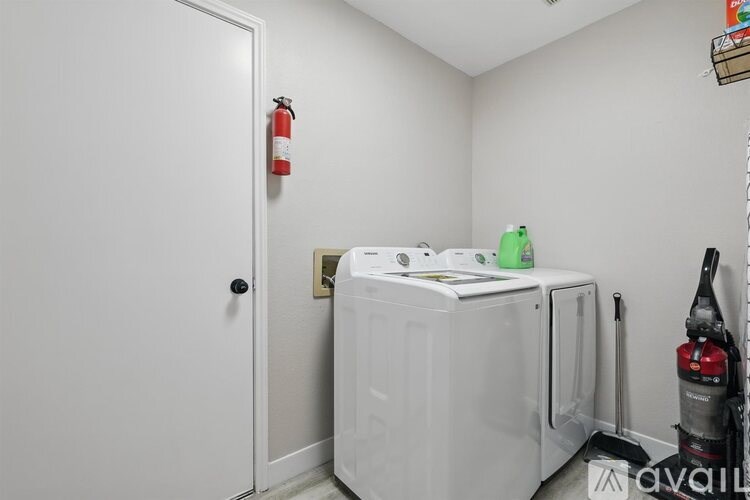 A white washing machine sits in a small laundry room.