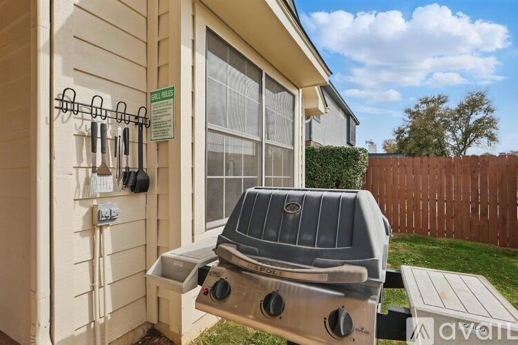 A grill is on a patio outside a house.