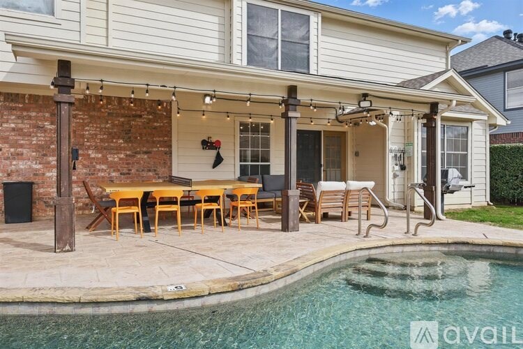A house with a pool and a covered patio area.