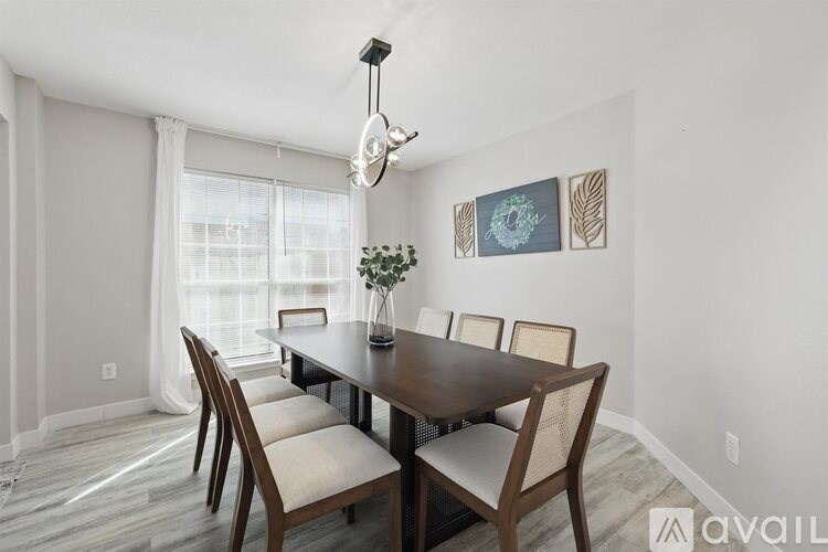 A dining room with a wooden table and chairs.