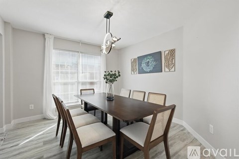A dining room with a wooden table and chairs.