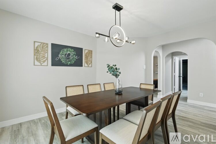 A dining room with a wooden table and chairs.