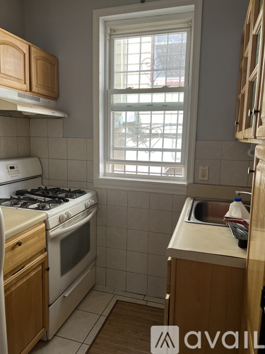 A kitchen with a stove, sink, and window.