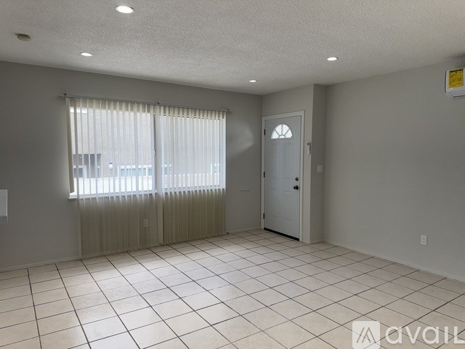 A room with a door, window, and tiled floor.