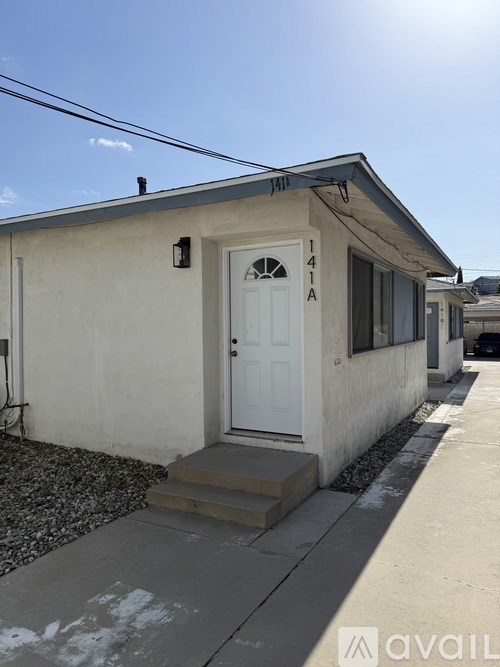 A small house with the number 1414 on the front door.