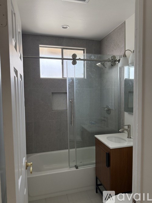 A bathroom with a walk-in shower and a white sink.