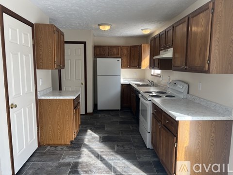 A kitchen with wooden cabinets and a white refrigerator.
