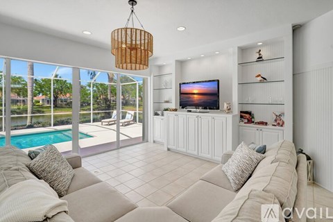 A living room with a large couch and a television on the wall.