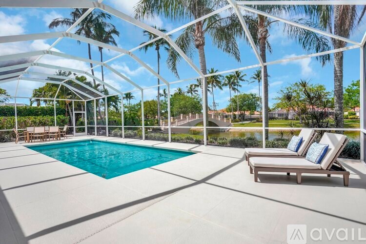 A pool area with a white canopy and a pool with a greenish blue water.