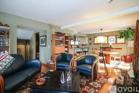 A living room with a black couch and a coffee table.