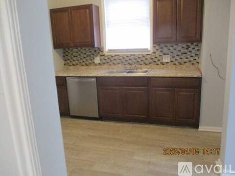 A kitchen with brown cabinets and a tiled backsplash.