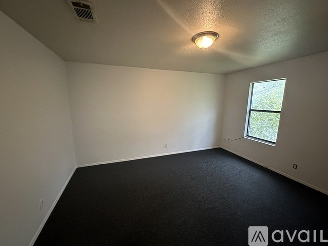 A room with a window and a light on the ceiling.