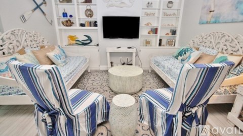 A living room with two striped chairs and a white table.