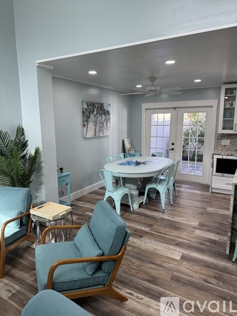A living room with a blue chair and a white table.