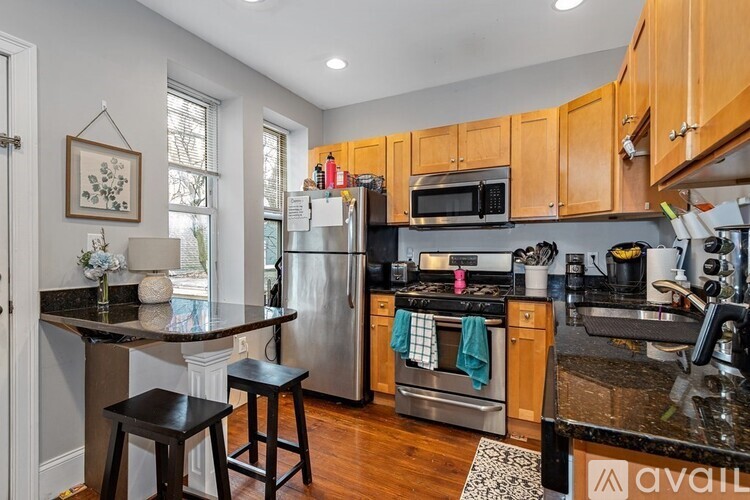 A kitchen with wooden cabinets and a black countertop.