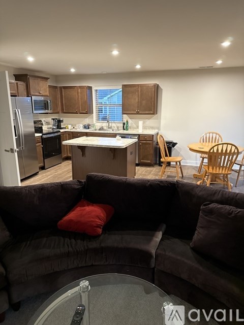 A kitchen with a refrigerator, microwave, oven, and sink is visible.