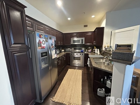 A kitchen with dark wood cabinets and stainless steel appliances.