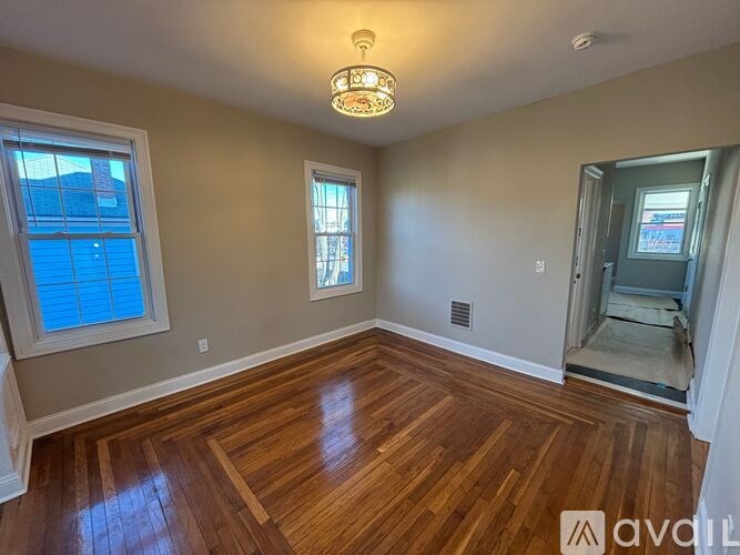 A room with wooden flooring and a window.