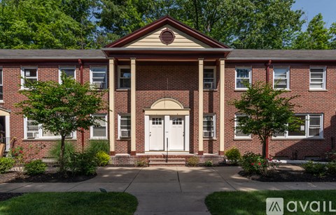 A red brick building with a white door and windows.