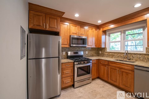 A kitchen with wooden cabinets and a stainless steel refrigerator.