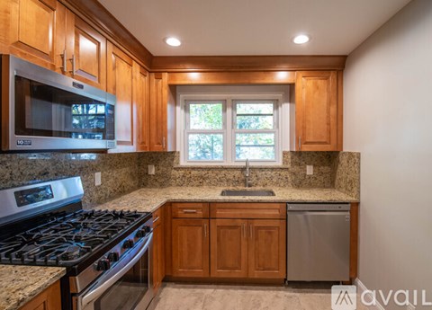 A kitchen with wooden cabinets and a granite countertop.