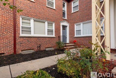 A red brick building with a white door and windows.