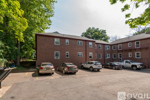 A parking lot with cars and a brick building in the background.