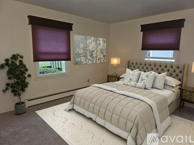 A bedroom with a large bed and a potted plant.