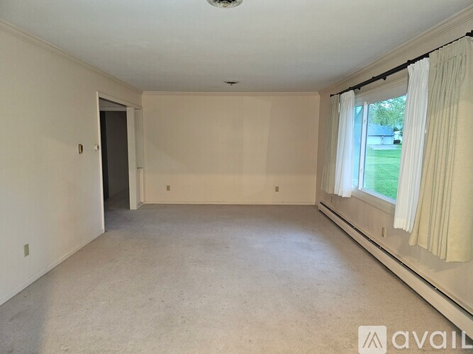 A spacious room with a window and a door.