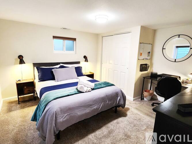 A bedroom with a bed, nightstand, and a mirror on the wall.