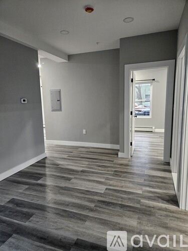 A hallway with a tiled floor and a doorway leading to another room.