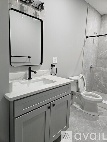 A bathroom with a sink, mirror, and toilet.