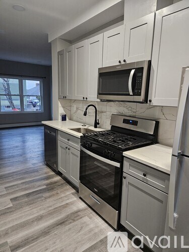 A kitchen with white cabinets and a black stove top oven.