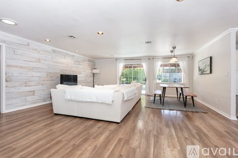 A living room with a white couch and a wooden wall.