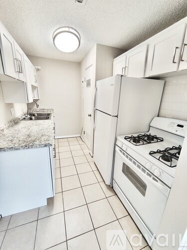 A kitchen with white appliances and cabinets.