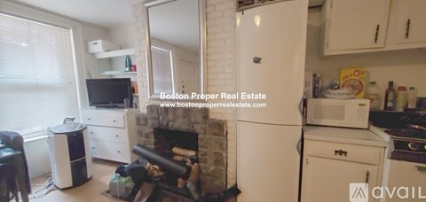 A kitchen with a white fridge and a fireplace.